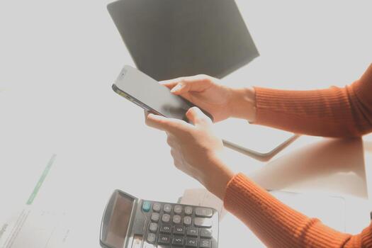 Asian Businesswoman Using laptop computer and working at office with calculator document on desk, doing planning analyzing the financial report, business plan investment, finance analysis concept. photo