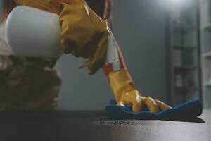 Office Cleaning Service. Janitor Spraying Desk. Workplace Hygiene photo