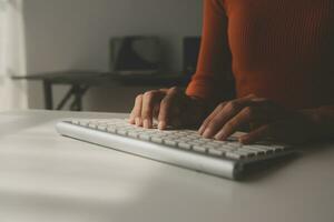 Asian Businesswoman Using laptop computer and working at office with calculator document on desk, doing planning analyzing the financial report, business plan investment, finance analysis concept. photo