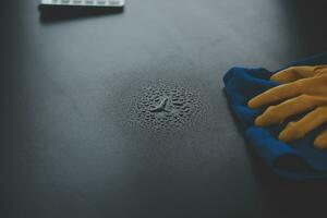 Office Cleaning Service. Janitor Spraying Desk. Workplace Hygiene photo