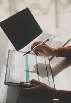 Asian Businesswoman Using laptop computer and working at office with calculator document on desk, doing planning analyzing the financial report, business plan investment, finance analysis concept. photo