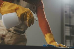 Office Cleaning Service. Janitor Spraying Desk. Workplace Hygiene photo