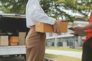 asiático mujer recepción producto desde entrega hombre a hogar, joven propietario mujer orden producto desde teléfono inteligente solicitud, mujer con en línea negocio o SME concepto. foto