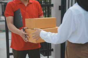 Asian Woman Receiving Product from delivery man at Home, Young Owner Woman Order Product from Smartphone Application, Woman with Online Business or SME Concept. photo