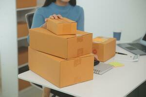 Business woman start up small business entrepreneur SME success .freelance woman working at home with Online Parcel delivery. SME and packaging deliveryconcept photo