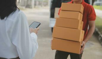 Asian Woman Receiving Product from delivery man at Home, Young Owner Woman Order Product from Smartphone Application, Woman with Online Business or SME Concept. photo