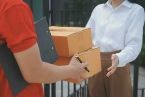 Asian Woman Receiving Product from delivery man at Home, Young Owner Woman Order Product from Smartphone Application, Woman with Online Business or SME Concept. photo