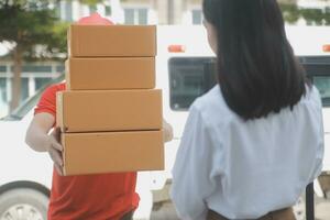 Asian Woman Receiving Product from delivery man at Home, Young Owner Woman Order Product from Smartphone Application, Woman with Online Business or SME Concept. photo