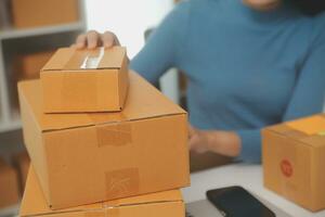 Business woman start up small business entrepreneur SME success .freelance woman working at home with Online Parcel delivery. SME and packaging deliveryconcept photo