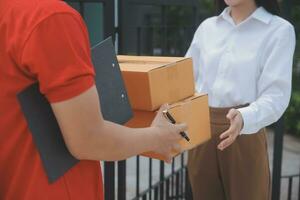 Asian Woman Receiving Product from delivery man at Home, Young Owner Woman Order Product from Smartphone Application, Woman with Online Business or SME Concept. photo