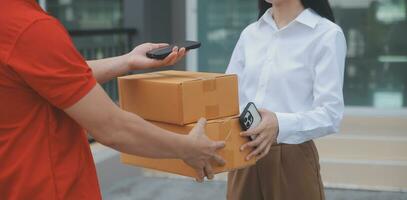 Asian Woman Receiving Product from delivery man at Home, Young Owner Woman Order Product from Smartphone Application, Woman with Online Business or SME Concept. photo