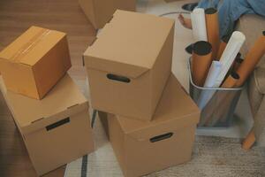 Beautiful young couple in love having fun unpacking things from cardboard boxes while moving in together in their new apartment photo