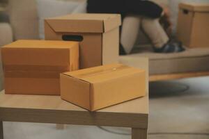 Beautiful young couple in love having fun unpacking things from cardboard boxes while moving in together in their new apartment photo