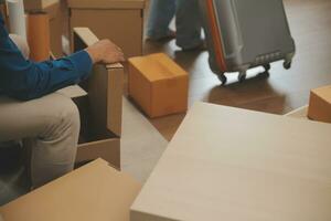 Beautiful young couple in love having fun unpacking things from cardboard boxes while moving in together in their new apartment photo