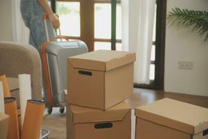 Beautiful young couple in love having fun unpacking things from cardboard boxes while moving in together in their new apartment photo