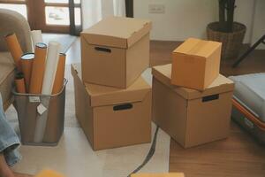 Beautiful young couple in love having fun unpacking things from cardboard boxes while moving in together in their new apartment photo