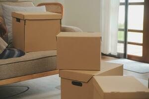 Beautiful young couple in love having fun unpacking things from cardboard boxes while moving in together in their new apartment photo