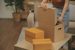 Beautiful young couple in love having fun unpacking things from cardboard boxes while moving in together in their new apartment photo