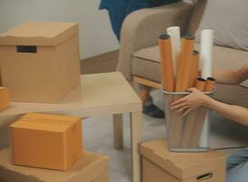 Beautiful young couple in love having fun unpacking things from cardboard boxes while moving in together in their new apartment photo