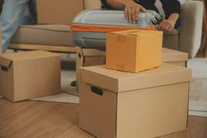 Beautiful young couple in love having fun unpacking things from cardboard boxes while moving in together in their new apartment photo