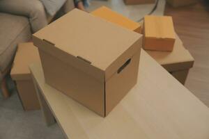 Beautiful young couple in love having fun unpacking things from cardboard boxes while moving in together in their new apartment photo