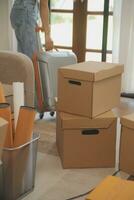 Beautiful young couple in love having fun unpacking things from cardboard boxes while moving in together in their new apartment photo