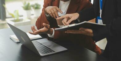 Financial analysts analyze business financial reports on a digital tablet planning investment project during a discussion at a meeting of corporate showing the results of their successful teamwork. photo