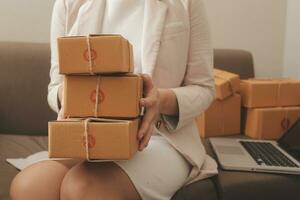 Business woman start up small business entrepreneur SME success .freelance woman working at home with Online Parcel delivery. SME and packaging deliveryconcept photo