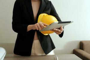 asian woman architect in shirt looking on internet online blueprint document project of green building. female interior designer worker working desktop computer monitor typing keyboard photo