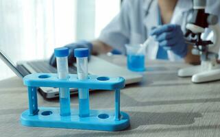 Young scientists conducting research investigations in a medical laboratory, a researcher in the foreground is using a microscope photo