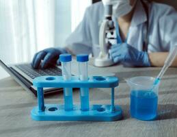 Young scientists conducting research investigations in a medical laboratory, a researcher in the foreground is using a microscope photo