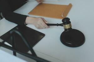 Male lawyer working with contract papers and wooden gavel on tabel in courtroom. justice and law ,attorney, court judge, concept. photo