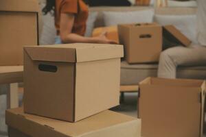 Beautiful young couple in love having fun unpacking things from cardboard boxes while moving in together in their new apartment photo