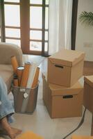 Beautiful young couple in love having fun unpacking things from cardboard boxes while moving in together in their new apartment photo