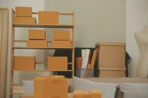 Beautiful young couple in love having fun unpacking things from cardboard boxes while moving in together in their new apartment photo