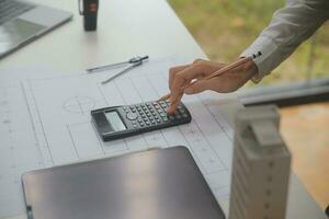 reunión de trabajo en equipo de ingenieros, trabajo de dibujo en la reunión de planos para el trabajo del proyecto con un socio en la construcción de modelos y herramientas de ingeniería en el concepto de sitio de trabajo, construcción y estructura. foto