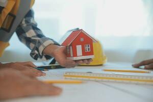 Construction and structure concept of Engineer or architect meeting for project working with partner and engineering tools on model building and blueprint in working site, contract for both companies. photo