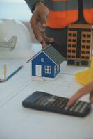 Construction and structure concept of Engineer or architect meeting for project working with partner and engineering tools on model building and blueprint in working site, contract for both companies. photo