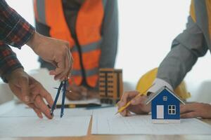 Construction and structure concept of Engineer or architect meeting for project working with partner and engineering tools on model building and blueprint in working site, contract for both companies. photo