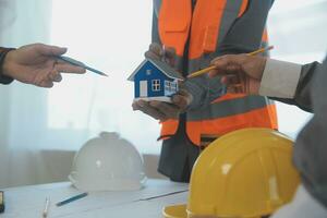 Construction and structure concept of Engineer or architect meeting for project working with partner and engineering tools on model building and blueprint in working site, contract for both companies. photo