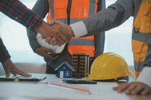 Construction and structure concept of Engineer or architect meeting for project working with partner and engineering tools on model building and blueprint in working site, contract for both companies. photo
