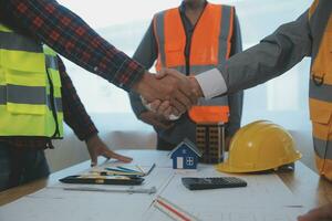 Construction and structure concept of Engineer or architect meeting for project working with partner and engineering tools on model building and blueprint in working site, contract for both companies. photo
