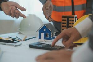 Construction and structure concept of Engineer or architect meeting for project working with partner and engineering tools on model building and blueprint in working site, contract for both companies. photo