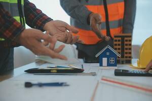 Construction and structure concept of Engineer or architect meeting for project working with partner and engineering tools on model building and blueprint in working site, contract for both companies. photo