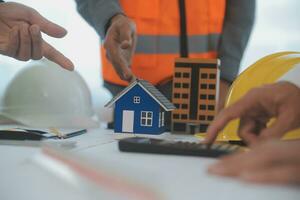 Construction and structure concept of Engineer or architect meeting for project working with partner and engineering tools on model building and blueprint in working site, contract for both companies. photo