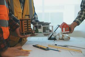 Construction and structure concept of Engineer or architect meeting for project working with partner and engineering tools on model building and blueprint in working site, contract for both companies. photo
