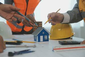 Construction and structure concept of Engineer or architect meeting for project working with partner and engineering tools on model building and blueprint in working site, contract for both companies. photo