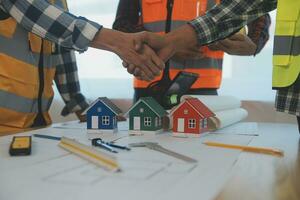 Construction and structure concept of Engineer or architect meeting for project working with partner and engineering tools on model building and blueprint in working site, contract for both companies. photo