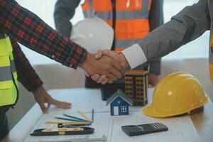 Construction and structure concept of Engineer or architect meeting for project working with partner and engineering tools on model building and blueprint in working site, contract for both companies. photo
