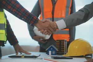 Construction and structure concept of Engineer or architect meeting for project working with partner and engineering tools on model building and blueprint in working site, contract for both companies. photo